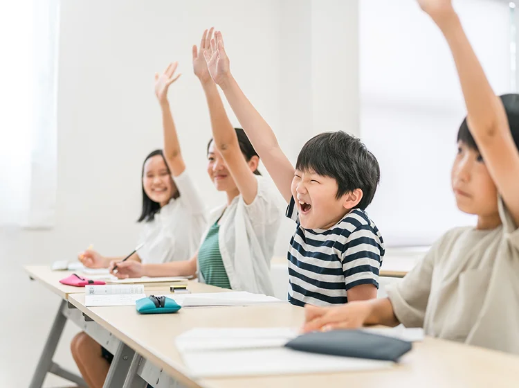 授業中に手を上げる子供の写真