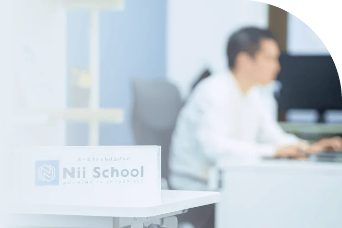 教室内の椅子に座る教師の画像